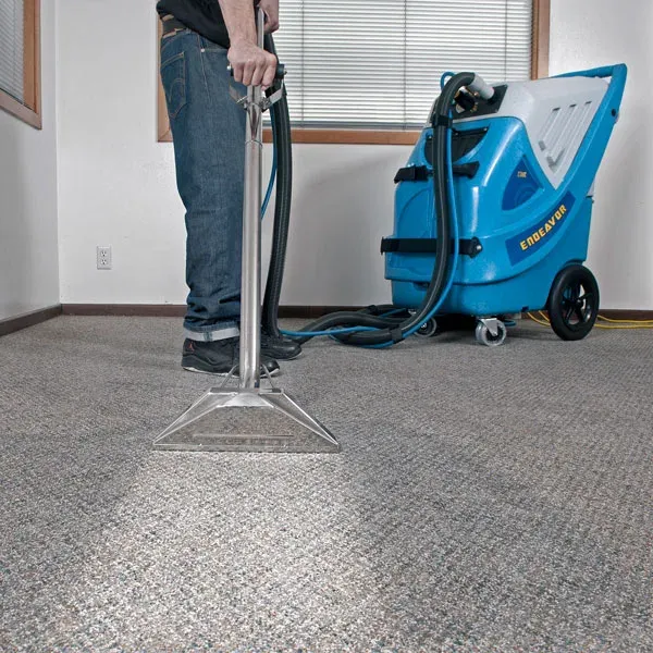 Carpet cleaning machine working on a grey carpet