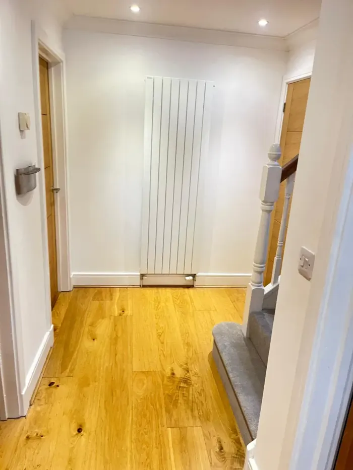Clean hallway with an oak floor and white walls