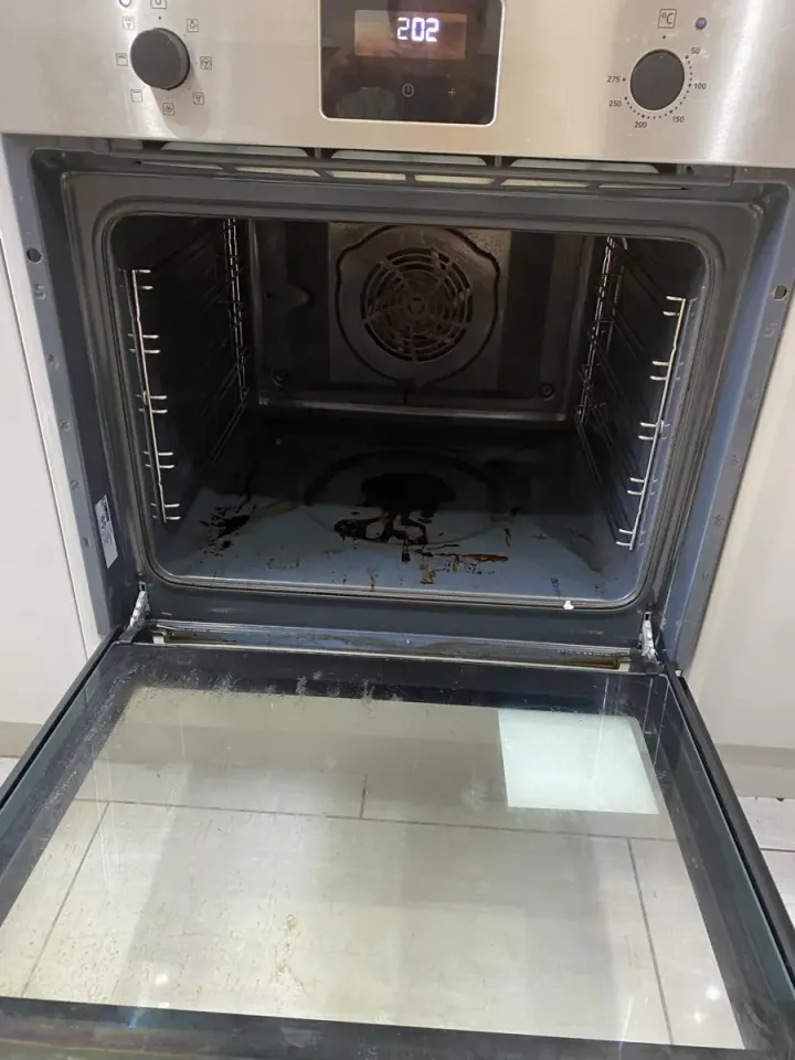 Oven interior with burnt-on grease and debris before cleaning